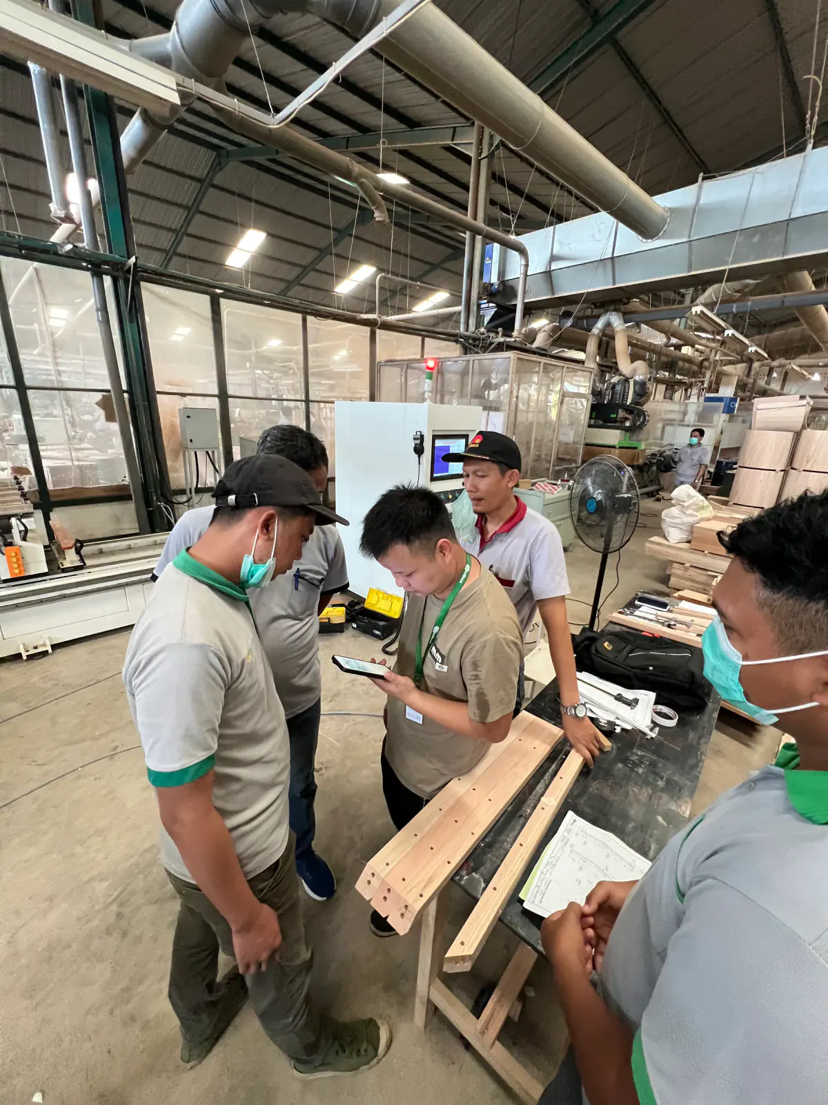 Technical team reviewing chair component machining